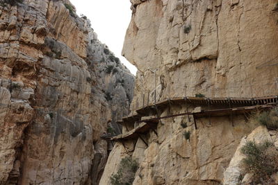 Low angle view of bridge by mountain