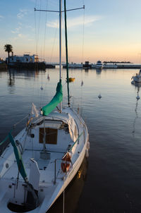 Boats moored on sea against sky during sunset