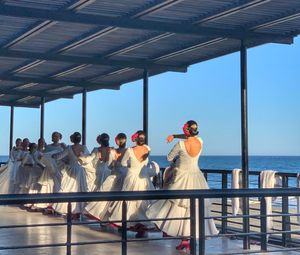 Rear view of people looking at sea against clear sky