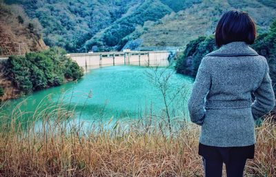 Rear view of woman standing in lake