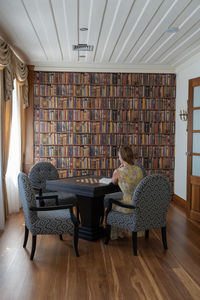 Woman sitting on chair at home and reading a book