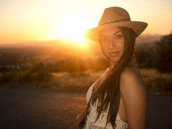 Portrait of woman wearing hat against sky during sunset