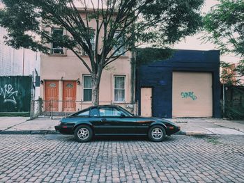 Car on street by buildings in city