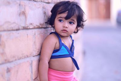 Cute girl standing against wall