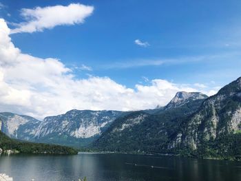 Scenic view of lake by mountains against sky