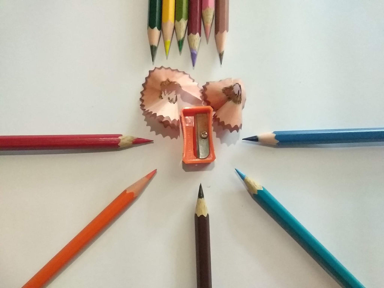 HIGH ANGLE VIEW OF COLORED PENCILS ON TABLE AGAINST WHITE BACKGROUND