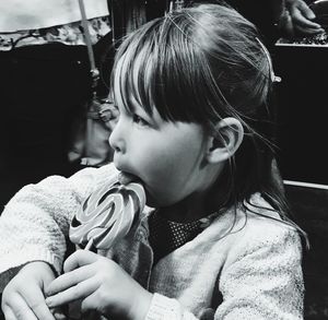 Close-up of cute girl licking candy in store