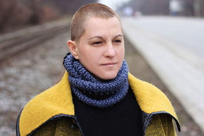 Woman looking away standing on railroad track during winter