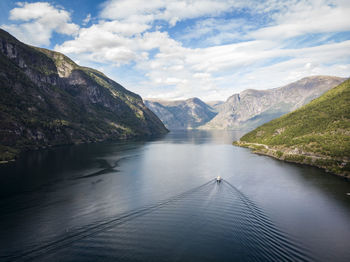 Scenic view of lake by mountains against sky