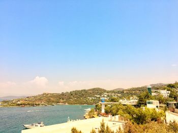 Townscape by sea against blue sky