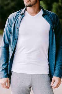 Midsection of man wearing jacket while standing in park