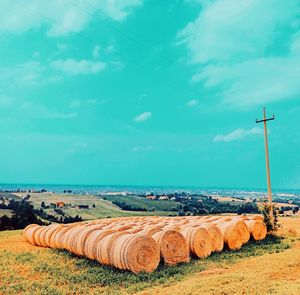 Hay bales on field against sky