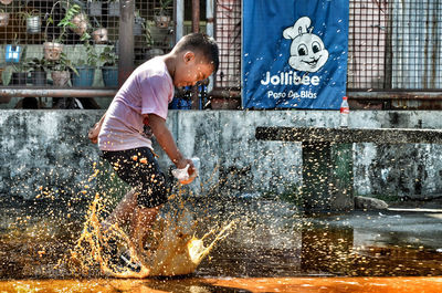 Side view of a man splashing water