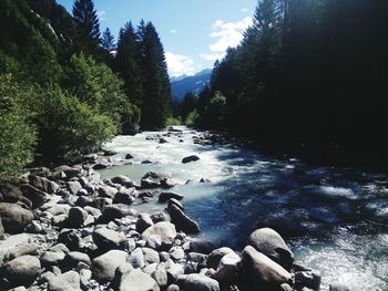 View of pebbles on water against sky