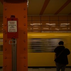 Rear view of man standing in subway