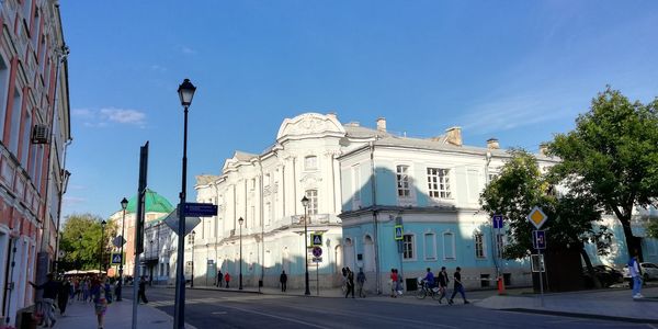 Buildings in city against clear blue sky