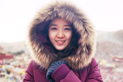 Portrait of smiling young woman wearing fur coat