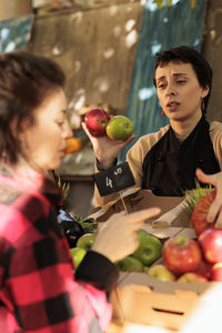 Portrait of young woman holding tomatoes