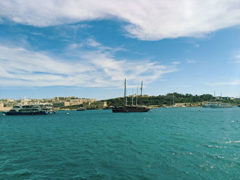 Sailboats in sea against blue sky