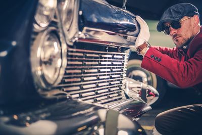 Man looking at vintage car in city
