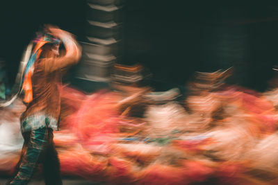 Blurred motion of man and woman standing at night