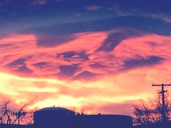 Low angle view of silhouette buildings against dramatic sky