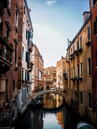 Canal amidst buildings against sky