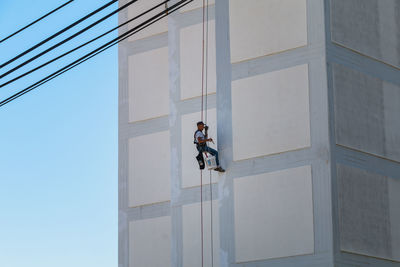 Low angle view of man working on building