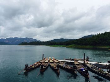 Pier on lake against cloudy sky