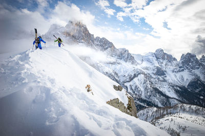 People hiking on snowcapped mountain during winter