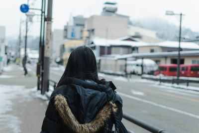 Rear view of woman on street in winter