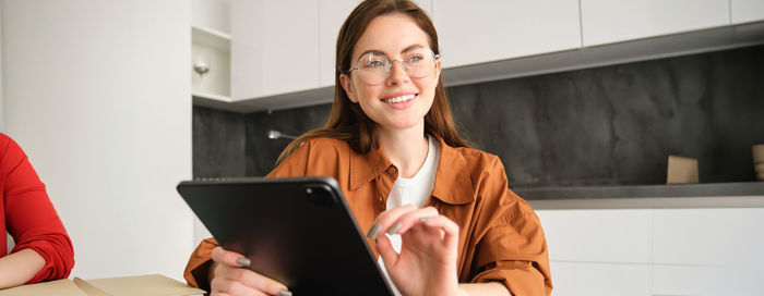 Young woman using laptop while sitting on table