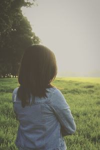 Rear view of woman standing on field