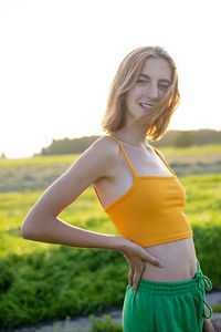 Portrait of young woman standing against sky