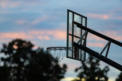 Low angle view of basketball hoop against sky during sunset