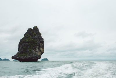 Rock formation on sea against sky