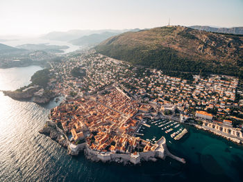 High angle view of townscape by sea against sky