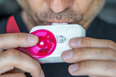 Close-up of man holding thermometer