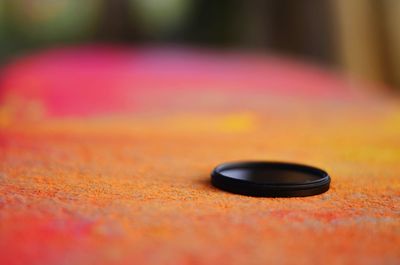 Close-up of black lid on colorful rock