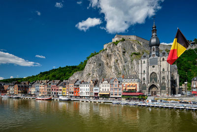 Buildings by river against sky