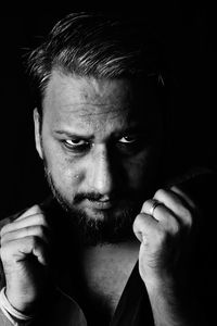 Close-up portrait of young man against black background