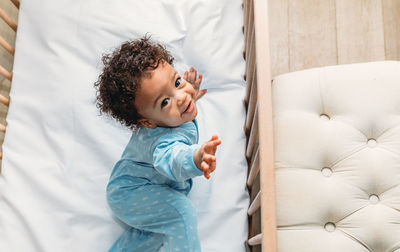 Cute baby boy lying on bed at home