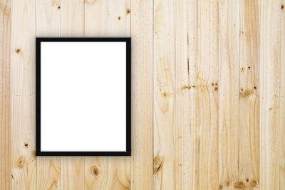 Close-up of blank picture frame on wooden wall