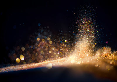 Defocused image of fireworks against sky at night