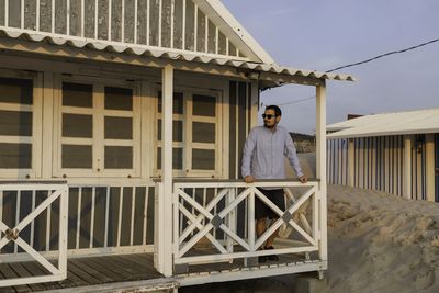 Portrait of man standing against building