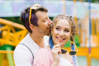 Happy couple in love kissing in an outdoor amusement park during leisure time lifestyle concept