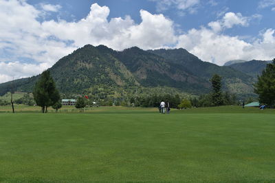 Scenic view of golf course against sky