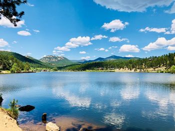 Scenic view of lake by mountains against sky