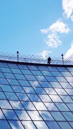 Low angle view of men working against sky