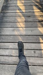 Low section of person standing on wooden floor
